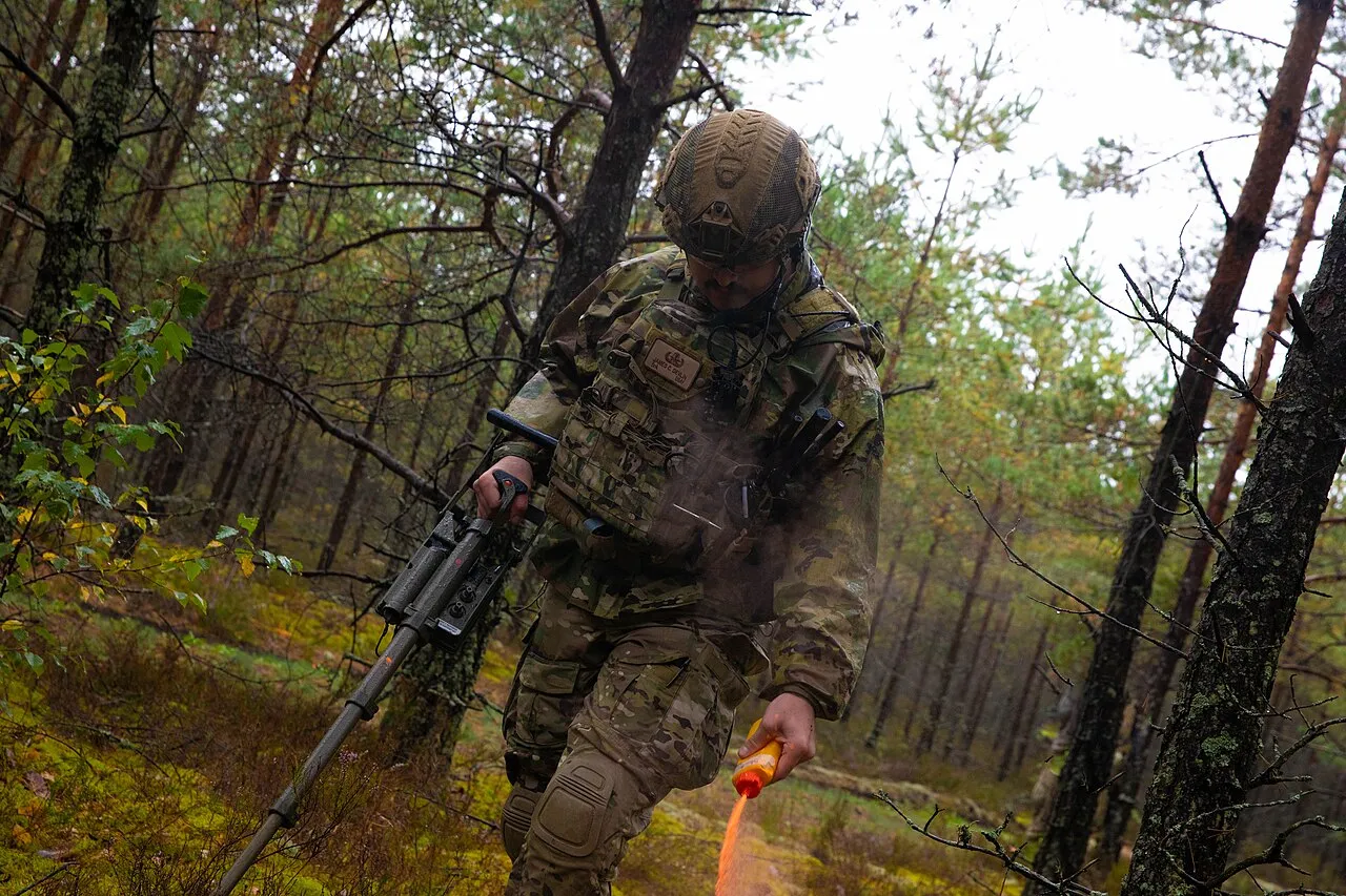Een militair markeert een veilig looppad op het Rūdninkai-trainingsterrein in Litouwen, waar het kampement voor de Duitse brigade wordt gebouwd.